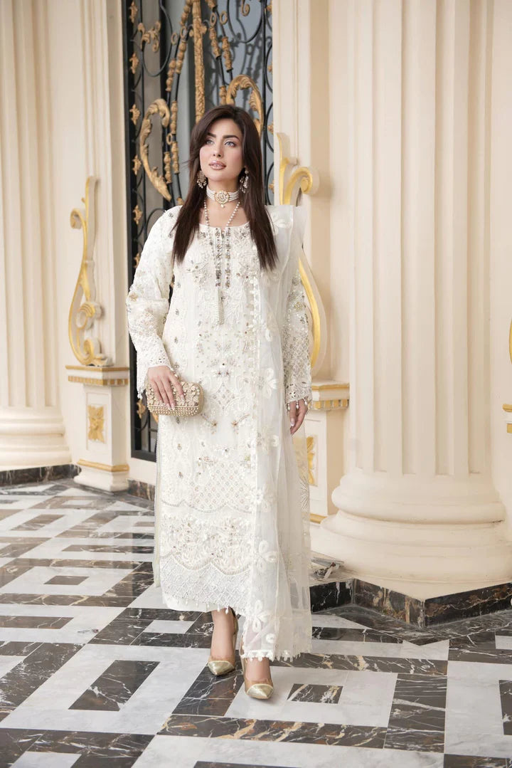 Woman in a white lace dress standing in an elegant interior setting